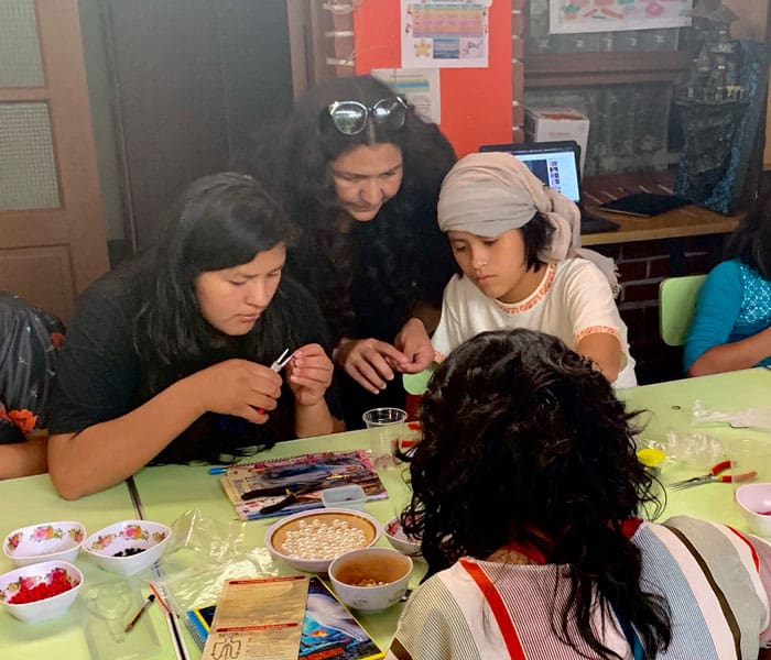 Lorena Simons (center) teaches girls at Our Home shelter in Cochabamba, Bolivia, to make rosaries. (Matthew Sim/Bolivia)