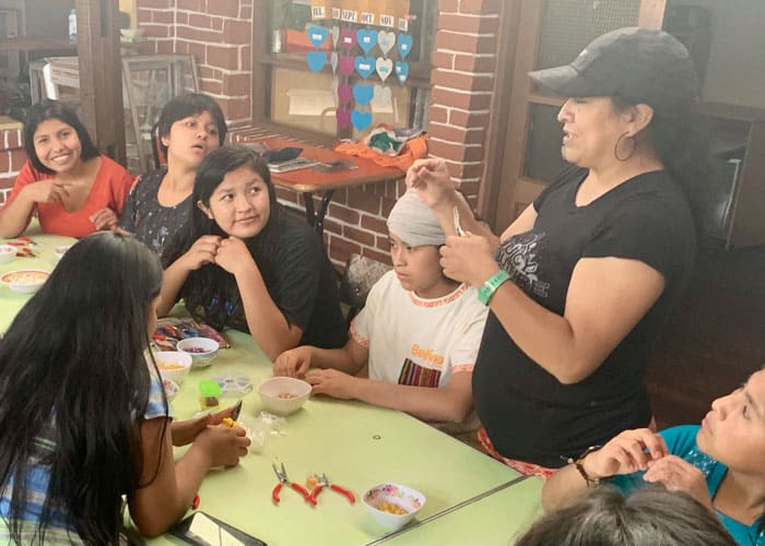 Rossy Bedoya (with black hat) visits girls at Our Home shelter who were victims of abuse and teaches them how to make rosaries. (Matthew Sim/Bolivia)