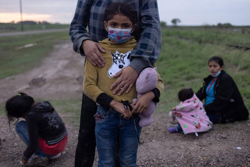 A migrant family from Honduras seeking asylum in the U.S. waits to be transported to a Border Patrol processing facility after crossing the Rio Grande into La Joya, Texas, May 13, 2021. (CNS photo/Adrees Latif, Reuters)