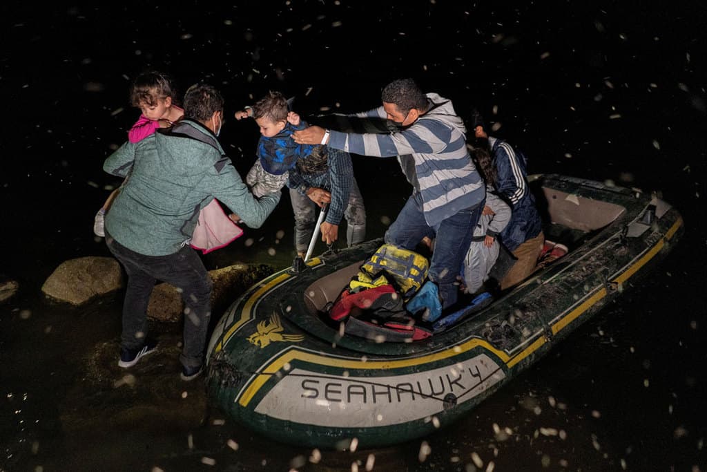 Asylum-seeking families in Roma, Texas, disembark an inflatable raft May 4, 2021, after crossing the Rio Grande from Mexico. (CNS photo/Go Nakamura, Reuters)