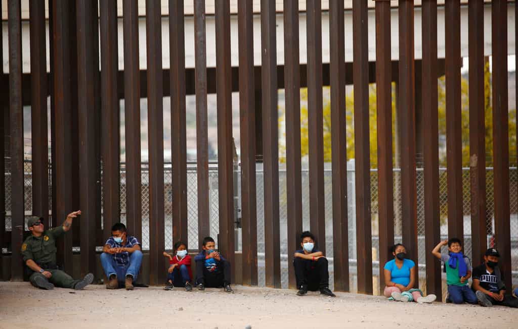 A Border Patrol agent near El Paso, Texas, plays a rock-throwing game with asylum-seeking migrants who crossed the Rio Grande from Mexico May 14, 2021. (CNS photo/Jose Luis Gonzalez, Reuters)