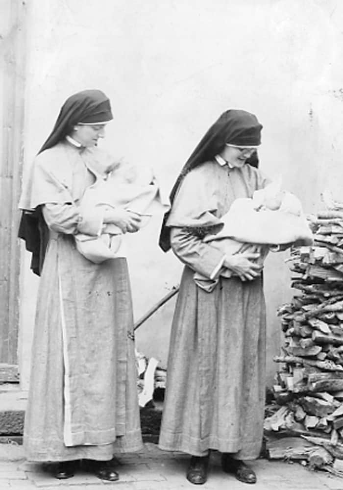 Sisters Lawrence Foley (l.) and Monica Moffatt hold babies in Yeungkong in 1923. (Maryknoll Mission Archives)