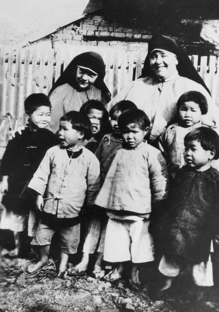 Sister Paul McKenna (l.) and Mother Mary Joseph Rogers with children in China in 1926. (Maryknoll Mission Archives)