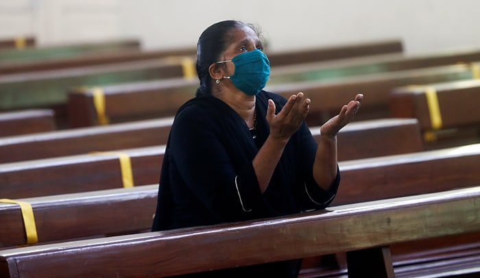 WOMAN PRAYS INDIA After World Mission Sunday Mass at St. Ferdinand Church, pastor Father Jason Torba and Cardinal Blase Cupich greet the congregation, including all those who do mission in Chicago. (Julie Jaidinger, Chicago Catholic/U.S.)