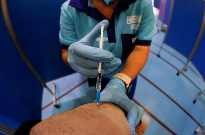20210702T0830-VACCINES-VATICAN-MEDICAL-ASSOCIATIONS-1251283 A health care worker administers the second dose of the Pfizer BioNTech COVID-19 vaccine to a man at a vaccination center in Ronda, Spain, June 30, 2021. (CNS photo/Jon Nazca , Reuters)