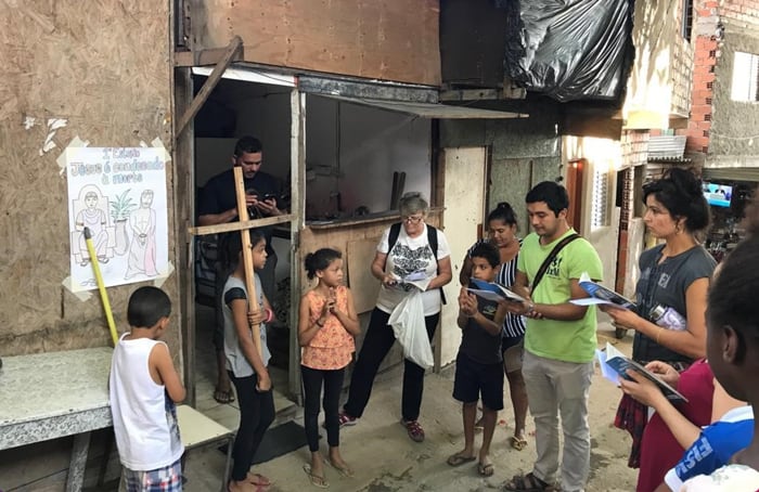 Margarita Durán (right) joins Holy Rosary Sister Ann Griffin (white shirt), Spiritan Seminarian Oscar Britez and community members at outdoor Stations of the Cross. (Anastasia Lee/Brazil)