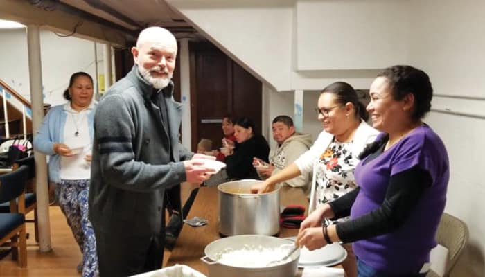 Father Lopez-Cardinale, pastor of St. Benedict Church, enjoys a meal with community members at a parish event in 2019. (Courtesy of Alejandro Lopez-Cardinale/U.S.)