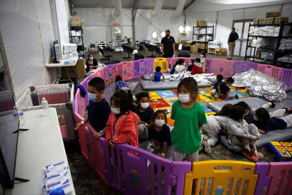 Young unaccompanied migrants, ages 3 to 9, watch television inside a playpen March 30, 2021, at the holding facility in Donna, Texas, set up in February by U.S. Customs and Border Protection, an agency within the Department of Homeland Security. (CNS photo/Dario Lopez-Mills, Pool via Reuters)