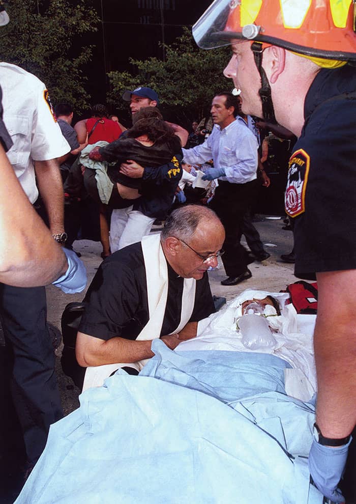 On Sept. 11, 2001, Richard Cohen took this photo of Maryknoll Father Raymond Nobiletti anointing and praaying over Elaine Duch, who worked on the 88th floor of the World Trade Center's north tower, where the first plane hit.