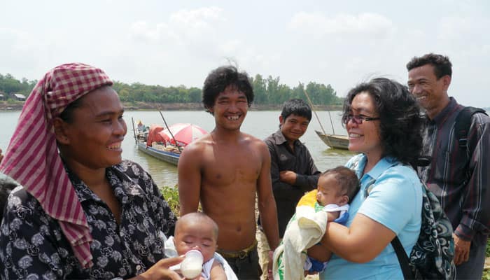 Sister Montiel (blue blouse) visits Long Mary, Man Koup and their children on the Bassac River, where Seedling of Hope purchased the family a boat. (Sean Sprague/Cambodia)