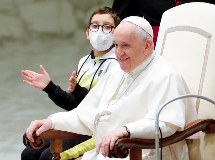 Pope Francis sits next to 10-year-old Paolo after the boy spontaneously walked on to the stage during the weekly general audience at the Vatican Oct. 20, 2021. (CNS photo/Remo Casilli, Reuters)