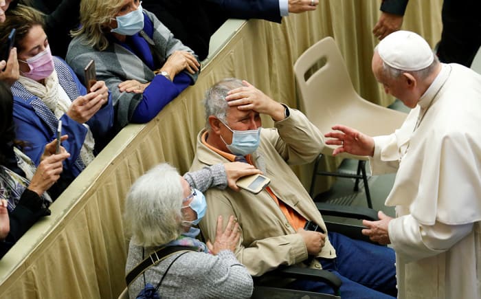 A man cries as he meets Pope Francis at the weekly general audience at the Vatican Oct. 20, 2021. (CNS photo/Remo Casilli, Reuters)