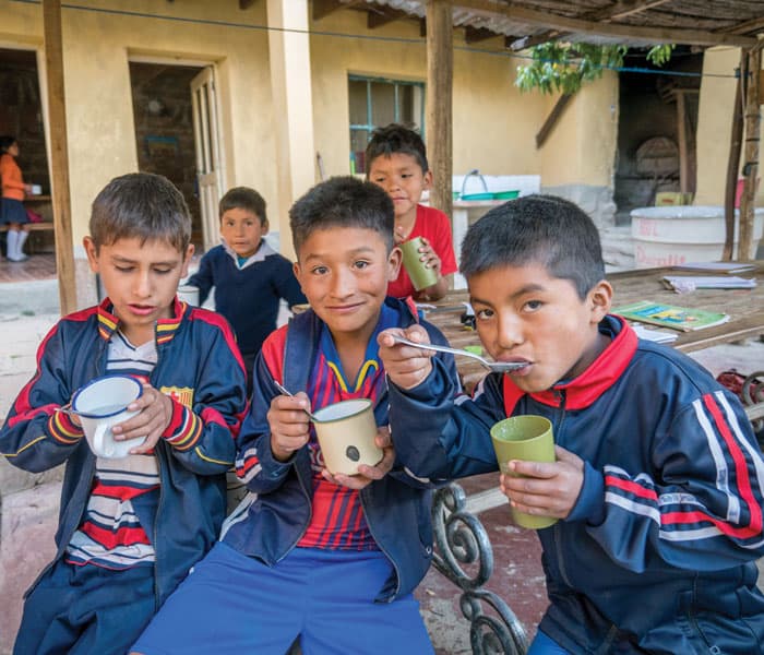 Children attending the after-school program enjoy a nutritious snack of oatmeal and milk, prepared by Lay Missioner Nguyen at the parish house in Tacopaya. (Nile Sprague/Bolivia)