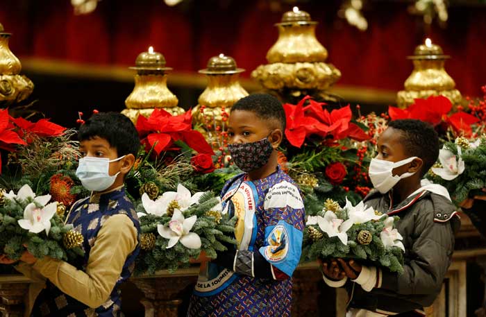 20211224T1400-POPE-CHRISTMAS-MASS-1514744 LITTLENESS OF CHRISTMAS: Children hold flowers at the start of Pope Francis' celebration of Christmas Eve Mass in St. Peter's Basilica at the Vatican Dec. 24, 2021. (CNS photo/Paul Haring)