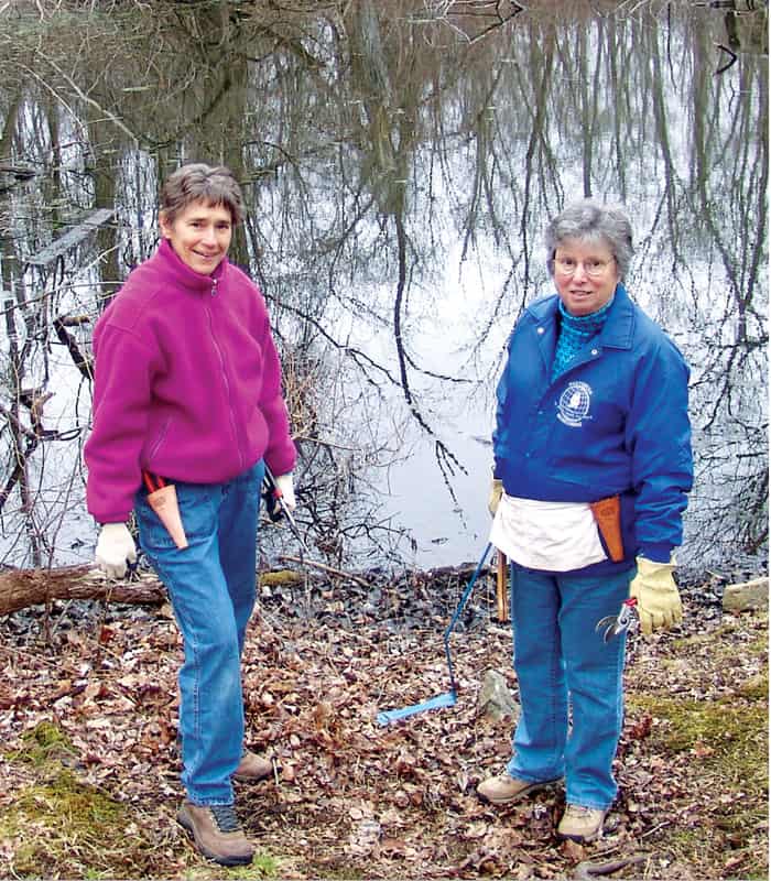 Maryknoll Sisters Janet Miller (left) and Doreen Longres prune trees on part of the Maryknoll Sisters center that is being conserved in perpetuity. (Lynn Monahan/U.S.) 