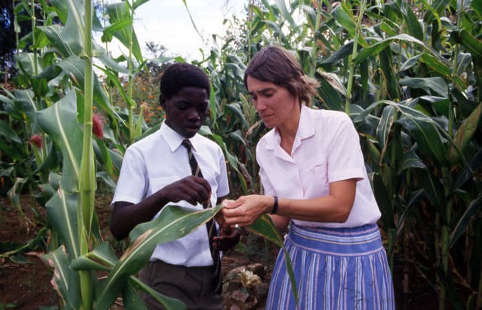 Sister Miller, trained in agriculture and animal husbandry at Gweru Teachers College in Zimbabwe, discusses farming techniques with a student in 1988. (Maryknoll Mission Archives)