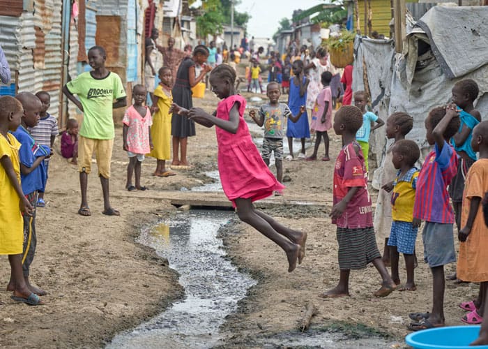 Children jump back and forth over a drainage ditch as they play. Residents are protected by U.N. peacekeeping troops. (Paul Jeffrey/South Sudan)