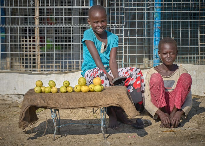 The families of children such as these two girls, shown selling fruit, were displaced from their homes following the outbreak of civil war in 2013. (Paul Jeffrey/South Sudan)