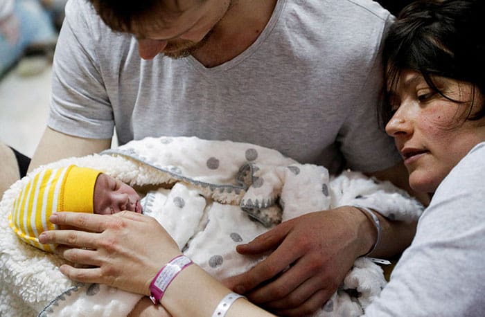 A couple in Kyiv, Ukraine, with their newborn baby take shelter in the basement of a perinatal center March 2, 2022, as air raid siren sounds are heard during Russia's invasion of Ukraine. (CNS photo/Valentyn Ogirenko, Reuters)