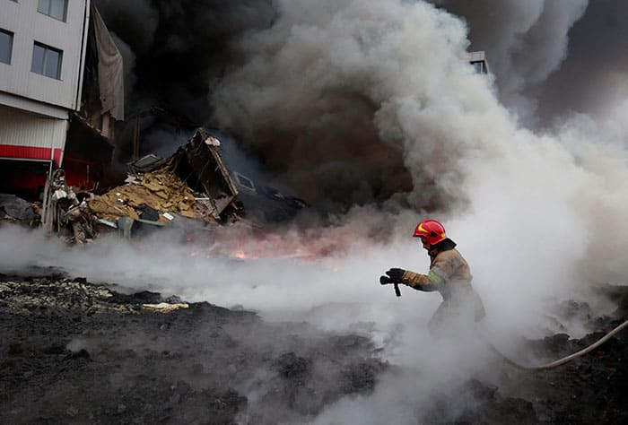 A firefighter works to extinguish fire at a warehouse shelled in Chaiky, Ukraine, March 3, 2022, as Russia's invasion of Ukraine continues. (CNS photo/Serhii Nuzhnenko, Reuters)