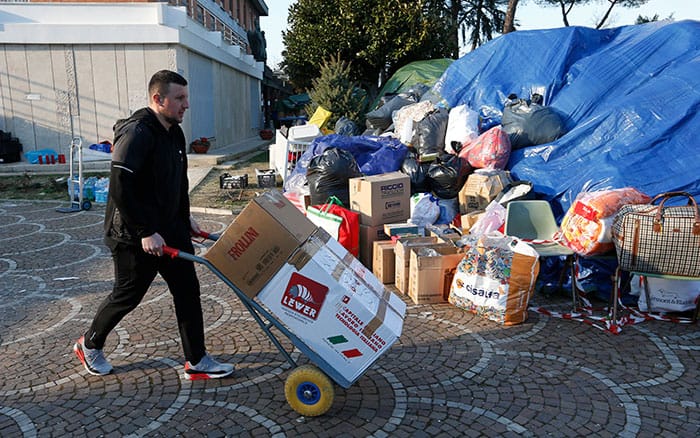 A man pushes boxes past mounds of humanitarian assistance to be sent to Ukraine at the Basilica of St. Sophia, the church of the Ukrainians in Rome, March 7, 2022. (CNS photo/Paul Haring)