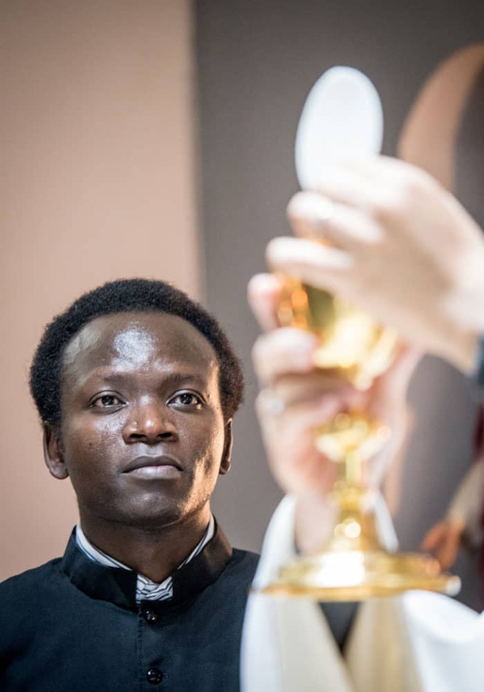 Seminarian John Siyumbu looks with fervor at consecration during Sunday Mass at San Pio X parish in Cochabamba. (Nile Sprague/Bolivia)