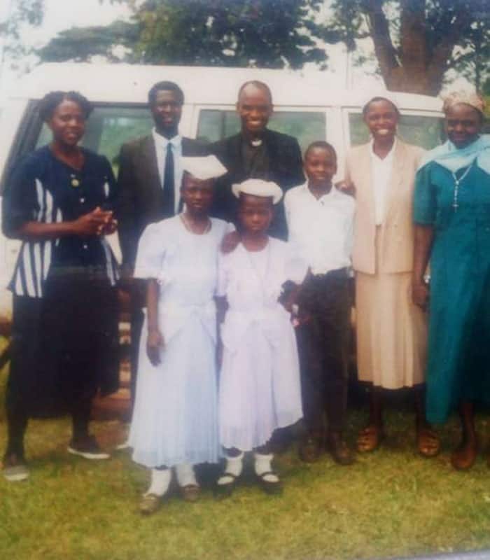 Young John Siyumbu is surrounded by his family on the day of his Confirmation.
