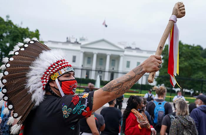 A demonstrator in Washington wears a traditional Native American headdress during an Indigenous Peoples' Day protest outside the White House Oct. 11, 2021. (CNS photo/Sarah Silbiger, Reuters)