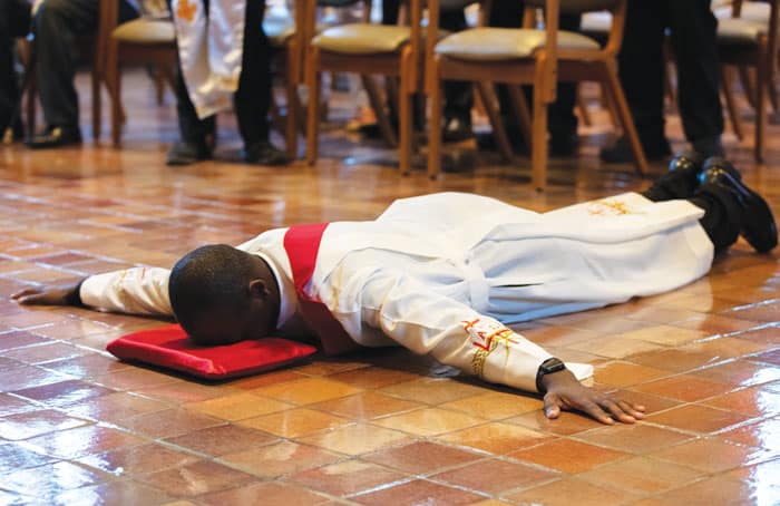 Deacon John Siyumbu lies prostrate before the altar. (Octavio Durán/U.S.)