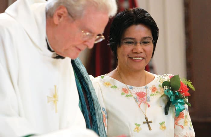 At the Maryknoll Sisters Center, Sister Avelino smiles as the late Maryknoll Father Jack Sullivan signs her final vow documents in 2014. (CNS photo, Gregory A. Shemitz/U.S.)