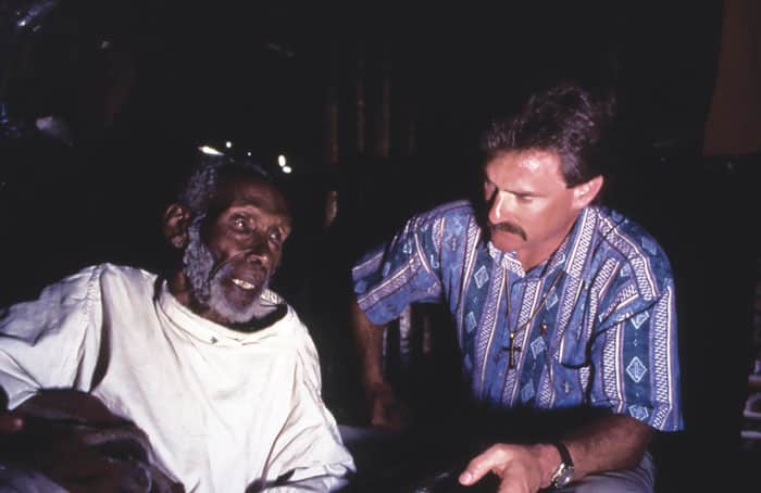 In a Nairobi slum, Maryknoll Brother William (Tim) Raible receives a blessing from a blind storyteller friend he visited often. (Sean Sprague/Kenya)