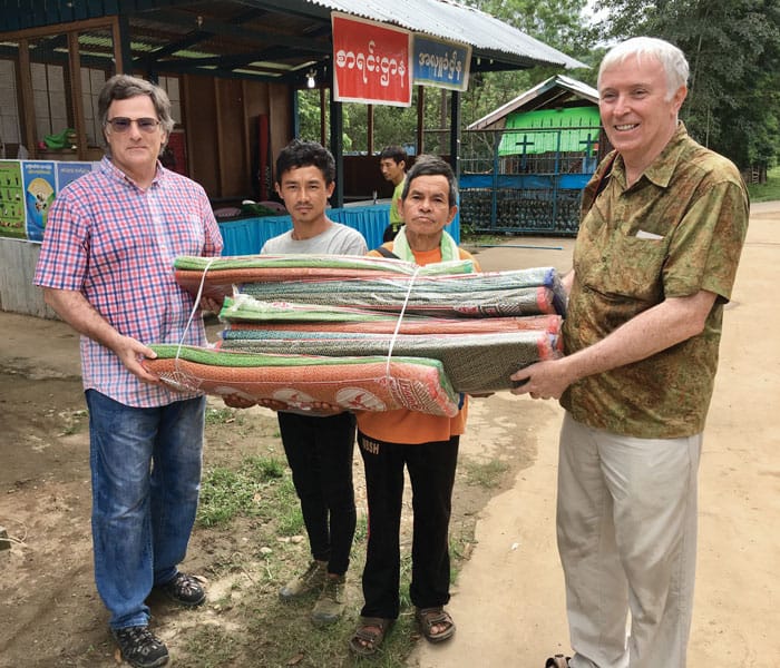 Maryknoll Brother William (Tim) Raible and volunteer Jim Mulqueen (right) distribute sleeping mats at internally displaced people camps in Myanmar. (John Beeching/Myanmar)