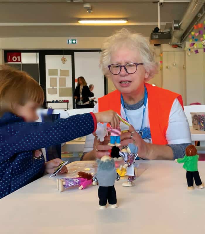 Maryknoll Affiliate Janet Alberti, who worked for 30 years in mental health, engages in play therapy with a Ukrainian child (face blurred for privacy). (Courtesy Janet Alberti/Poland)