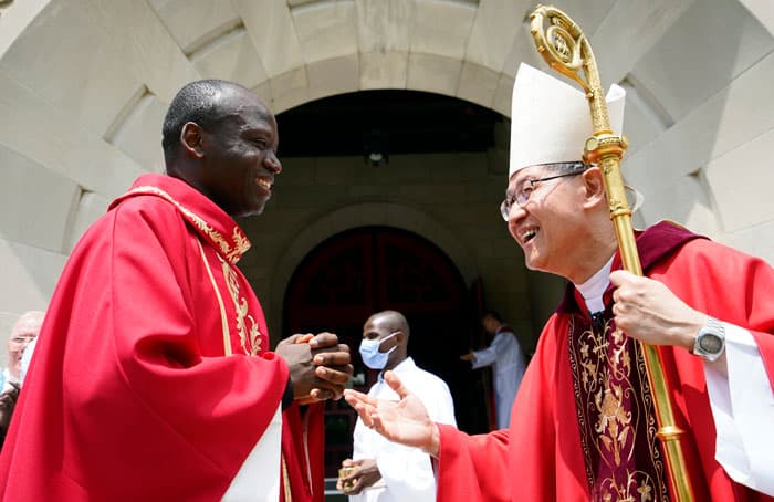 After World Mission Sunday Mass at St. Ferdinand Church, pastor Father Jason Torba and Cardinal Blase Cupich greet the congregation, including all those who do mission in Chicago. (Julie Jaidinger, Chicago Catholic/U.S.)