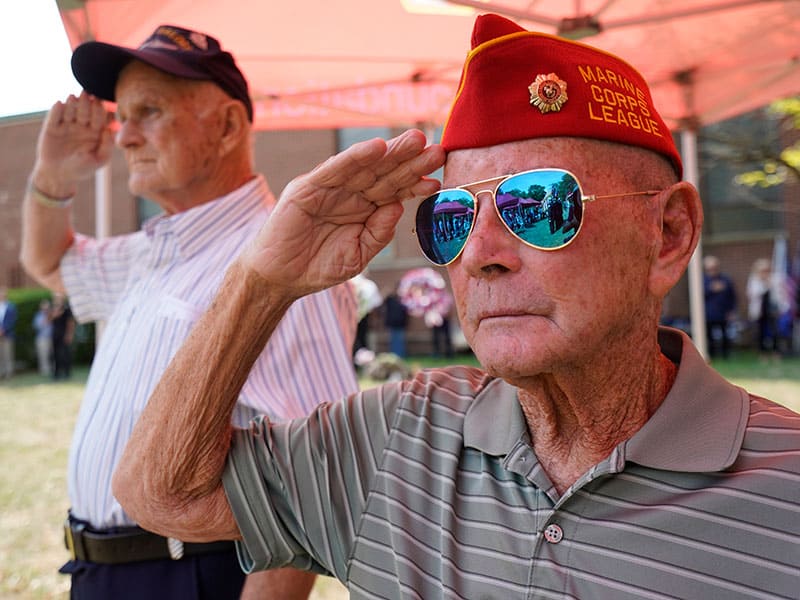 U.S. Marine veteran Tom Dicks, right, and U.S. Navy veteran Bob Egan salute during a memorial service marking the 55th anniversary of the death of Maryknoll Father Vincent R. Capodanno at Fort Wadsworth in Staten Island, N.Y., Sept. 4, 2022. Father Capodanno, a native of Staten Island, was killed while ministering as a U.S. Navy chaplain to wounded Marines on a battlefield in Vietnam. (CNS photo/Gregory A. Shemitz)