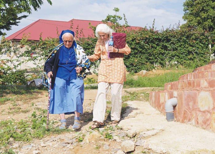 Maryknoll Lay Missioner Judy Walter (right) assists a religious sister on the grounds of the Lake House of Prayer on the shores of Lake Victoria. (Sean Sprague/Tanzania)