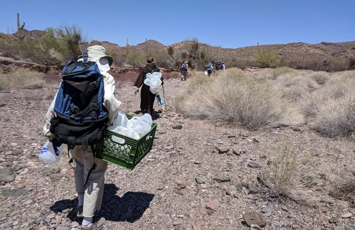 Members of Tucson Samaritans, a humanitarian aid organization, replenish water jugs along migrant trails in the Sonora/Arizona desert. (CNS photo/Peter Tran, Global Sisters Report)