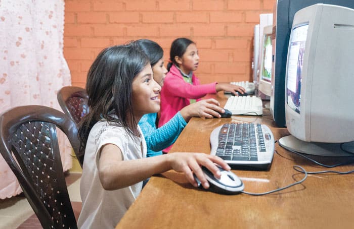 Young students enjoy computer classes at a neighborhood after-school program held in the home of Maryknoll Lay Missioners Tawny Thanh and Hiep Vu in Bolivia. (Nile Sprague/Bolivia)
