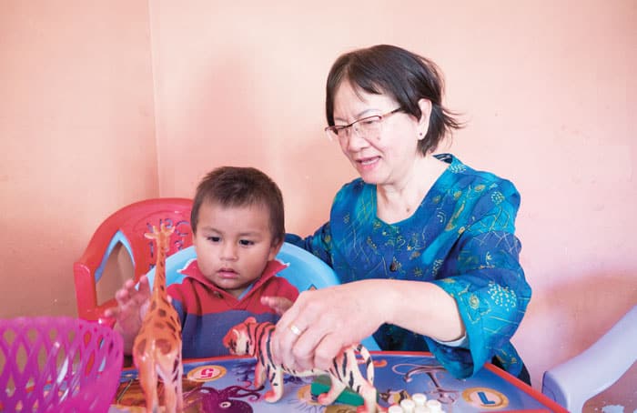 Maryknoll Lay Missioner Tawny Thanh tends to a child at the daycare of an institute run by the Misioneras Parroquiales del Niño Jesús de Praga in Cochabamba. (Nile Sprague/Bolivia)