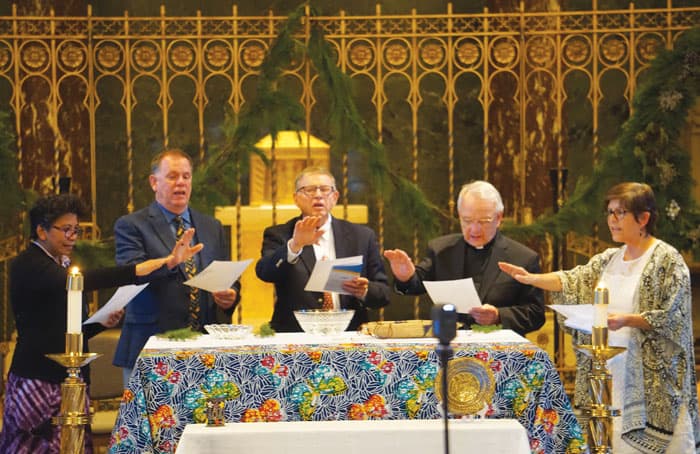 Leaders of Maryknoll expressions (left to right) Sister Genie Natividad, Ted Miles, Bob Short, Father Lance Nadeau and Elvira Ramirez bless the mission crosses. (Debbie Northern/U.S.)