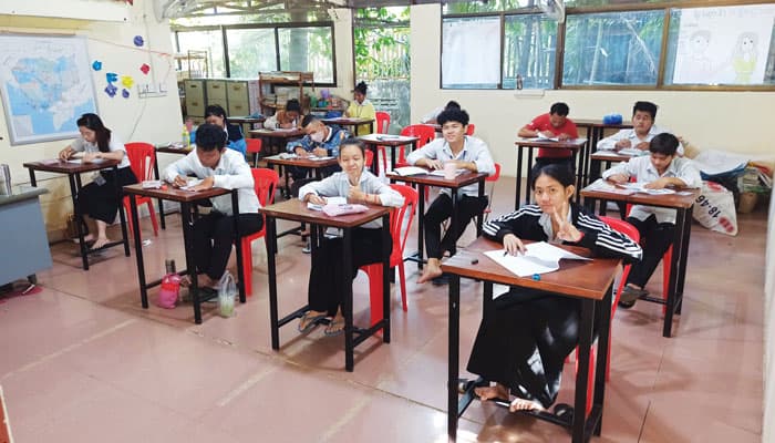 Students finishing the first term of a two-year academic program at the Deaf Development Programme sit in rows to take an end-of-the-year assessment. (Charlie Dittmeier/Cambodia)
