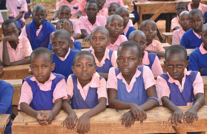 34-38-Educating-Heroes-01 Students share desks at Mukononi Primary School, located in the Kibwezi area severely impacted by climate change, where famine and hunger can keep children from learning. (Moses Njagua Gitahi/Kenya)