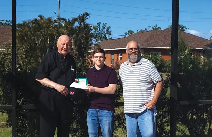 Elliot Courtney, shown with his father, is presented the Bishop Patrick Byrne Award by Maryknoll Father Leo Shea in Punta Gorda, Florida. (Courtesy of Leo Shea/U.S.)