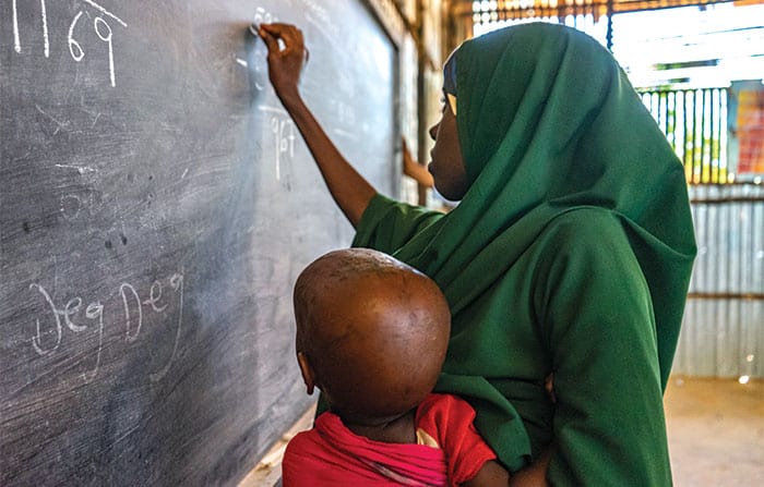 A woman in a refugee camp takes part in a JRS literacy program for adults. (Courtesy of Jesuit Refugee Service/Ethiopia)