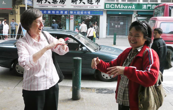 Maryknoll Sister Arlene Trant and a Deaf friend sign greetings to one another in Macau in 2012. (Sean Sprague/Macau)