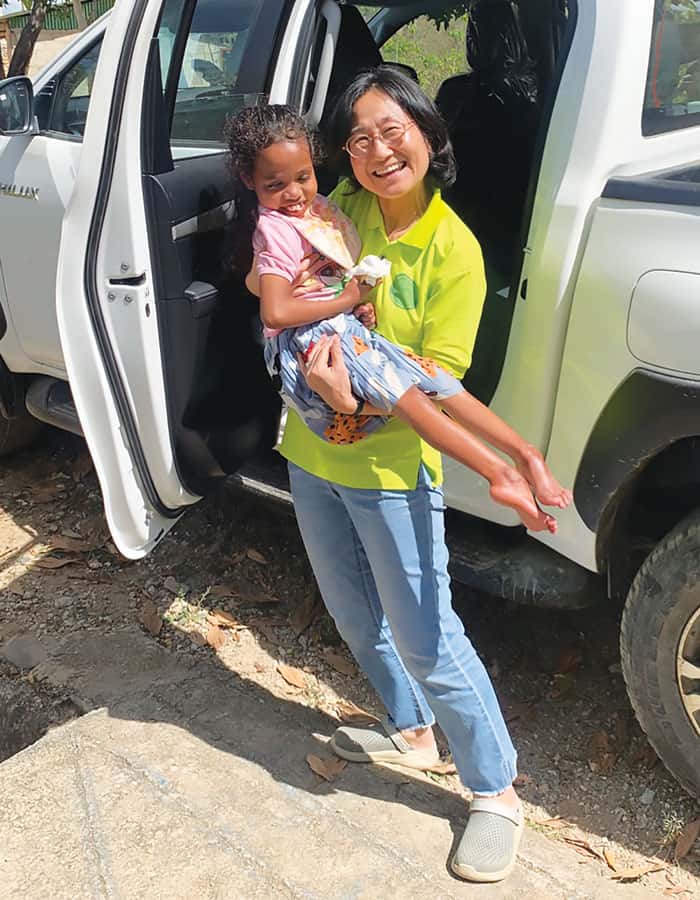 Maryknoll Sister Hyunjung Kim takes Rosalina home after a weekly program held at the clinic. The 11-year-old with a beautiful smile suffers from muscular dystrophy. (Courtesy of Hyunjung Kim/East Timor)