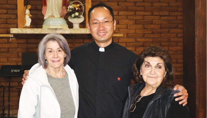 Matthew Sim is shown with altar society members Carmen Muela and Iris Marquez at Cristo Rey Church in El Paso, Texas. (Deirdre Cornell/U.S.)