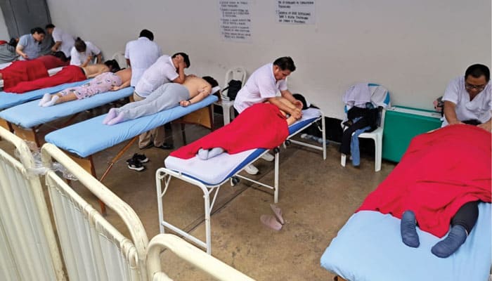 Blind students of massage therapy from the Casa Bartimeo training center in Lima practice on inmates at a women’s prison. (Courtesy of Kyungsu Son/Peru)