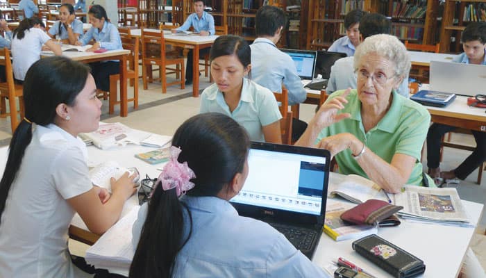 Maryknoll Sister Luise Ahrens talks with students in the library of the Royal University of Phnom Penh, which Maryknoll sisters helped to develop. (Sean Sprague/Cambodia)