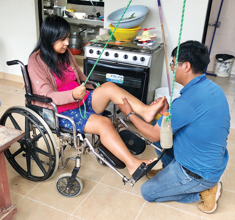 26-31-Joe-Filo-Loney-2 During a home visit in Entre Ríos, Willy García, a nurse with the Social Justice Foundation, teaches muscle strengthening exercises to Yeydy Olivera. (Meinrad Scherer-Emunds/Bolivia)